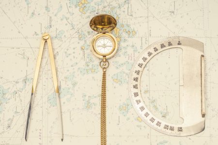 Navigation still-life. Skipper equipment, compass, ruler, protractor and a map. Sailing concept.